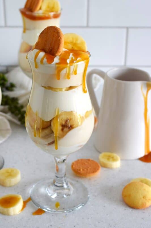 Layers of vanilla wafer cookies, homemade mascarpone cream, banana pudding, and freshly sliced bananas, these parfaits are quick and easy to make! Serve them family style or fancy them up by serving them in these individual glasses. Top with whipped cream and an optional caramel drizzle. They're a feast for the eyes! #banana #pudding #parfait #nobake #layered #dessert