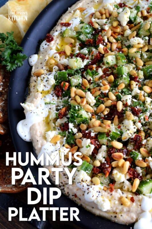 What's a party without dip? Hummus Party Dip Platter is a large, layered dip that's just perfect for entertaining a crowd. This all-in-one dip has hummus, sour cream, pine nuts, sun dried tomatoes, cucumbers, feta, and a few other ingredients too! Serve this on any occasion for a delicious, crowd-pleasing appetizer! #hummus #dip #appetizer #party #platter #spread