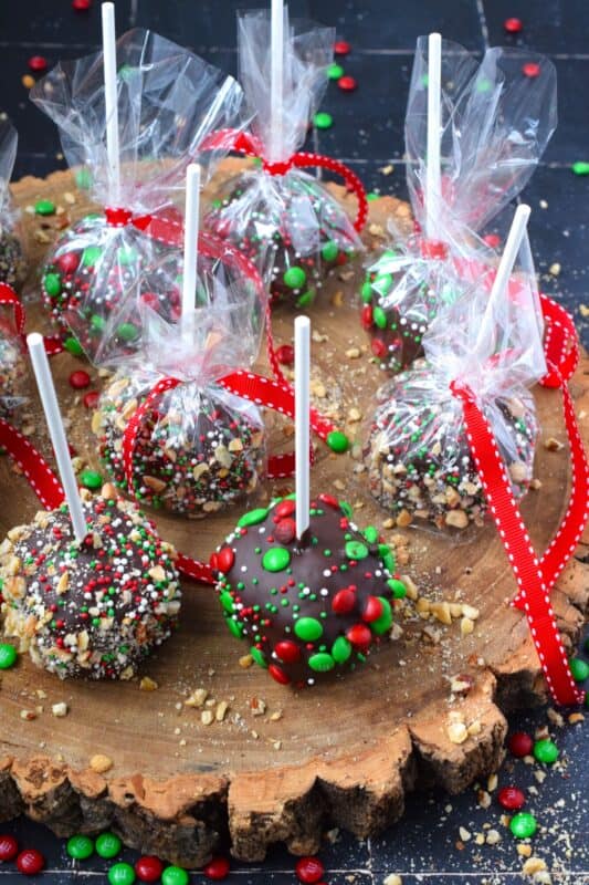 These cute little treats are so easy to make and just in time for Christmas! Rice Krispie Treat Lollipops are a no-bake treat with so many decorating options! Dip the balls in chocolate and let your imagination go wild with candy, sprinkles, nuts, etc.  Wrap and give these kids both young and old! #ricekrispie #treats #nobake #lollipop