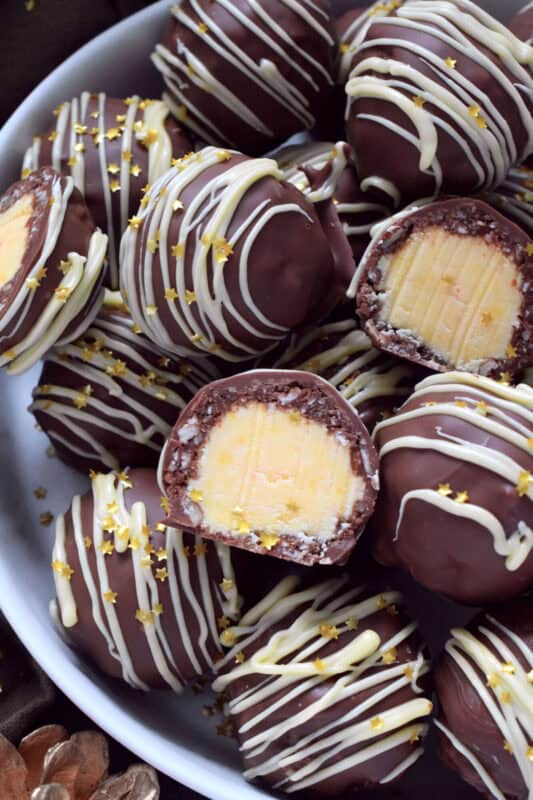 This recipe takes a popular and beloved Canadian classic, the Nanaimo Bar, and transforms it into the most delicious truffle balls complete with a sweet, custard-based center. Just one bite and you'll be so hooked that you'll want to make these again and again! #nanaimo #truffles #balls #holiday #nobake
