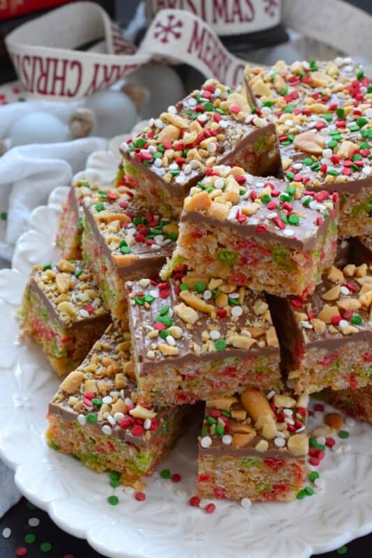 Remove the marshmallows from a Rice Krispie Treat and substitute it with melted chocolate and peanut butter for an even tastier treat!  Prepared with Christmas-coloured cereal, these Christmas Peanut Butter Rice Cereal Squares are just as delicious as they look!  Don't forget the sprinkles; they make everything more fun and festive! #peanutbutter #squares #chocolate #christmas #ricekrispie