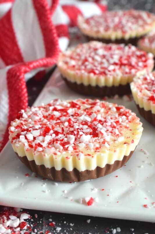 If you can melt chocolate, you can easily make these Muffin Tin Peppermint Cups! A layer of melted milk chocolate is followed by a layer of white melted chocolate and topped with a generous amount of crushed red and white candy canes. Decadent and rich, these festive treats are both fun to prepare and to eat! #melted #chocolate #milk #white #candycane #peppermint #nobake