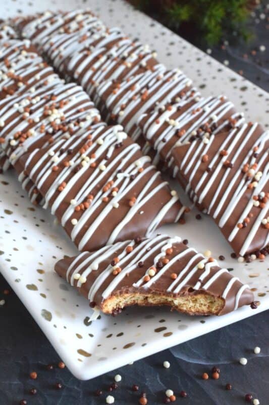 Deliciously light and crispy store-bought graham crackers are entirely dipped in melted milk chocolate and topped with a drizzle of melted white chocolate and sprinkles. These no-bake Chocolate Graham Squares are very easy to prepare and are perfect to package up in cellophane bags and gift to your favourite workmates! #graham #cracker #wafer #crumbs #chocolate #nobake #christmas #holiday #gift