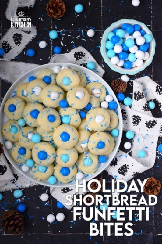 Colourful and festive, these Holiday Shortbread Funfetti Bites are prepared with a whipped shortbread cookie dough base which is flavoured with vanilla extract. Loaded with sprinkles and topped with candy-coated chocolate, these are not only cute, but also the perfect one-bite holiday confection! #cookies #christmas #frozen #mandm #mms #sprinkles #funfetti
