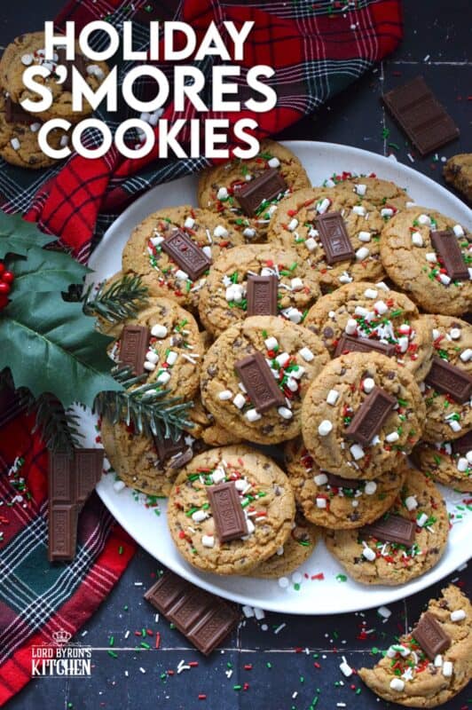 As the name implies, Holiday S'mores Cookies are prepared to resemble the flavour of everyone's favourite backyard fire treat! Baked with graham crumbs, chocolate, and brown sugar, these are a soft-baked cookie with a crispy edge. The texture of the crumbs with the milk chocolate is sensational. Topped with a bar of Hershey's chocolate, these cookies are a must this holiday season! #holiday #smores #cookies #christmas #baking