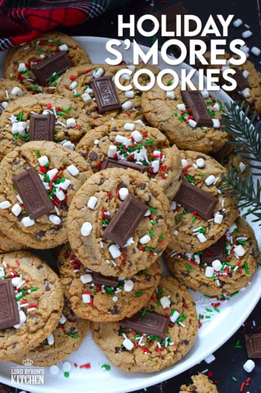 As the name implies, Holiday S'mores Cookies are prepared to resemble the flavour of everyone's favourite backyard fire treat! Baked with graham crumbs, chocolate, and brown sugar, these are a soft-baked cookie with a crispy edge. The texture of the crumbs with the milk chocolate is sensational. Topped with a bar of Hershey's chocolate, these cookies are a must this holiday season! #holiday #smores #cookies #christmas #baking