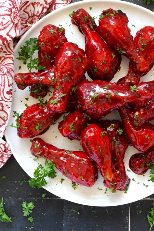 Spicy and flavourful with a slightly smoky taste, this Sweet Tandoori Chicken is mouthwateringly delightful! Tossed in cornstarch and baked in a hot oven, these chicken drumsticks are baked until crisp and then drenched in a sweet and sticky garlicky sauce that takes just minutes to prepare! #tandoori #spicy #chicken #drumsticks #baked