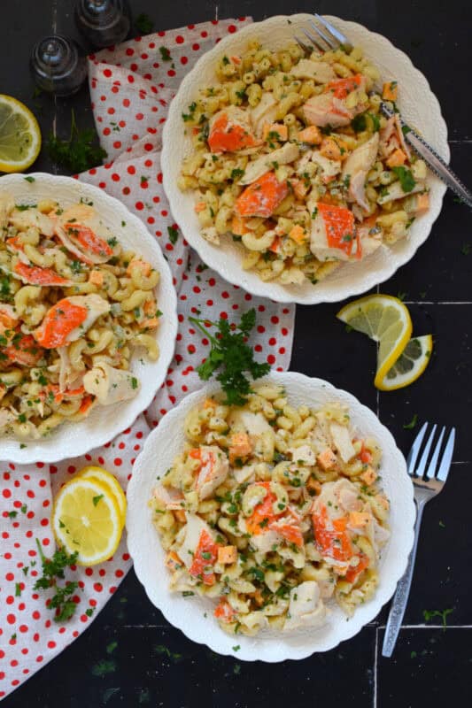 Flaked crab is tossed with cooked macaroni, dill pickles, and cheese in this Crab Macaroni Salad. The dressing is both creamy and tangy and is prepared with mayonnaise, vinegar, mustard, and old bay seasoning. This make-ahead salad is great for backyard barbecues and picnics! #salad #macaroni #seafood #crab #imitation