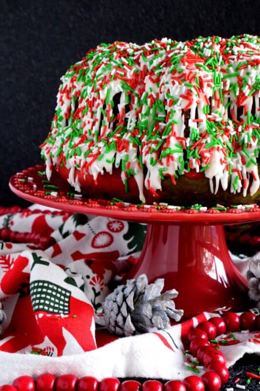 Kids of all ages will love a big slice of this Marbled Christmas Bundt Cake. This cake is festive, colourful, merry, and bright! It's made with yogurt so it will stay beautifully soft and moist. And, no matter what your age, everyone loves sprinkles! #bundt #sprinkles #marble #christmas #cake