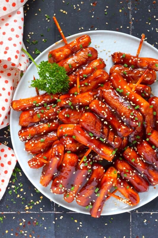 A popular Korean snack, tteok kkochi, are pan-fried rice cakes that become slightly crispy on the outside, yet retain that crave-worthy soft and chewy interior. Served on a wooden stick, these Rice Cake and Sausage Skewers are sweet and spicy and one of the best things I've eaten in a very long time! You simply have to try these! #ricecakes #sausage #skewers #korean #tteok