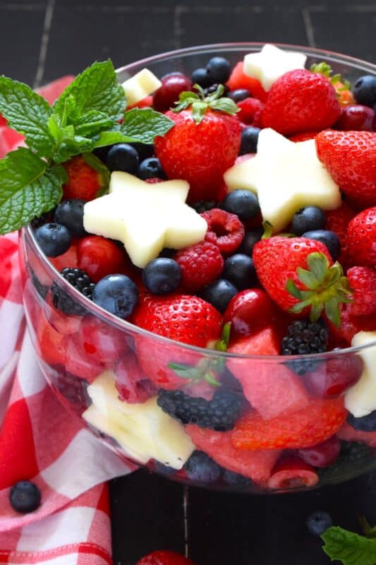 A perfectly gorgeous and healthy dessert option for your 4th of July party, this Celebration Berry and Fruit Salad is prepared with watermelon, strawberries, cherries, raspberries, blueberries, and apples cut into celebratory star shapes! Drizzled with a quick and easy glaze, this is a beautiful dessert everyone will want a taste of! #4thofjuly #fruit #berries #salad #redwhiteandblue