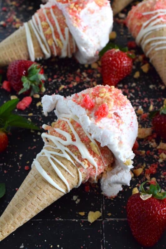 When it comes to serving up a scoop of ice cream at home, nothing beats doing so in one of these delicious drumstick sugar cones. Using store-bought cones, the inside is coated with melted white chocolate, which prevents ice cream from dripping out of the bottom, and rolled in strawberry shortcake crumbs! #strawberry #shortcake #icecream #cones