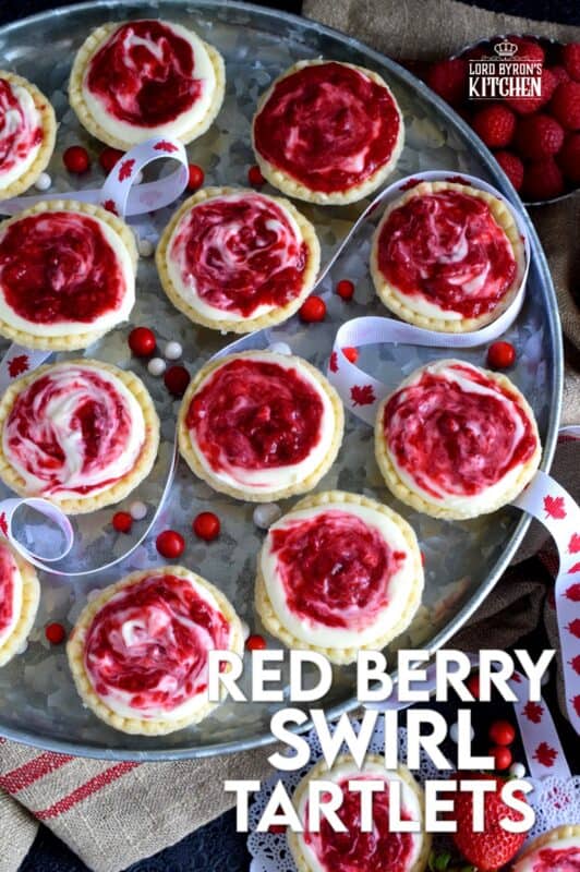 An easy to assemble treat perfect for any Canada Day celebration. Red Berry Swirl Tartlets are flaky, buttery, creamy, and sweet. Buy store-bought frozen tart shells to make this recipe fast and easier. These are stuffed with a cream cheese filling and a red berry compote! #tarts #tart #berry #tartlets