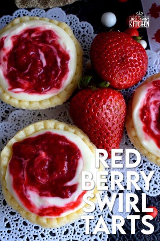 An easy to assemble treat perfect for any Canada Day celebration. Red Berry Swirl Tartlets are flaky, buttery, creamy, and sweet. Buy store-bought frozen tart shells to make this recipe fast and easier. These are stuffed with a cream cheese filling and a red berry compote! #tarts #tart #berry #tartlets