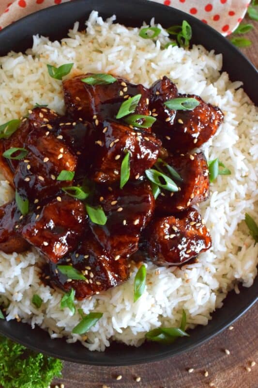 This sweet and sticky Glazed Pork Belly is cooked in two stages. First, the meat is boiled with seasonings and then fried before being cooked in a brown sugar, soy sauce, and rice wine reduction. Served with steamed rice, this is a meal that would please the toughest critic! #porkbelly #pork #belly