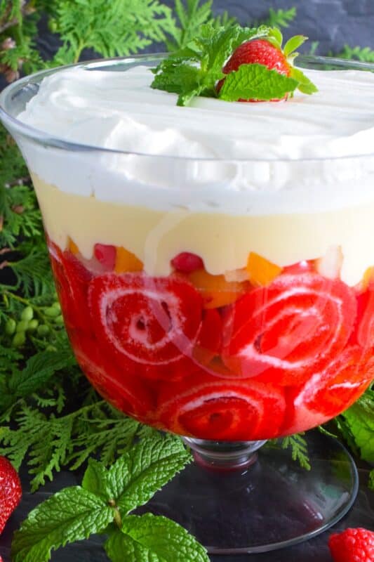 Mom's Jelly Roll Trifle starts with a store-bought raspberry jelly roll that is sliced and layered with raspberry jello, custard, fruit cocktail, and dream whip. This uncomplicated dessert, with its humble beginnings, is how I remember my mom's deliciously satisfying Sunday trifle. #trifle #cocktail #jellyroll #dessert