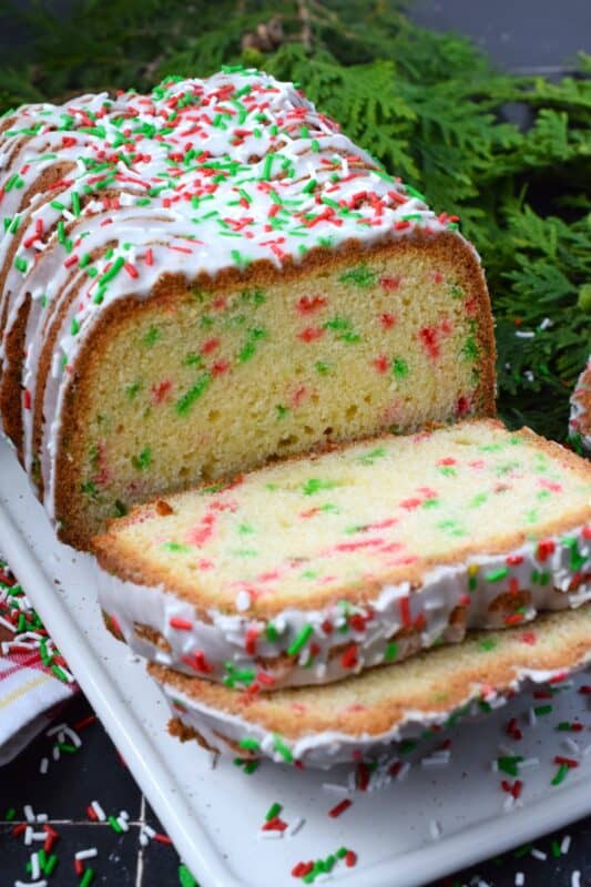 Moist and delicious, packed with festive holiday sprinkles, and drizzled with a sweet glaze, this Funfetti Christmas Loaf is a perfect dessert for kids both young and old! There is never a bad time to bake with sprinkles, but no other occasion demands it quite like Christmas! #funfetti #loaf #christmas #sprinkles #jimmies