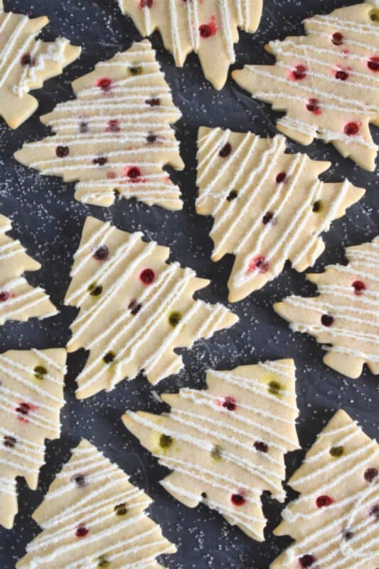 Dig out your tree-shaped cookie cutter and whip up a batch of these Christmas Tree Cookies! The ornaments are easy to make with crushed candy and they're baked right into the cookie dough. It's like adding decoration and flavour at the same time! #christmas #cookies #tree