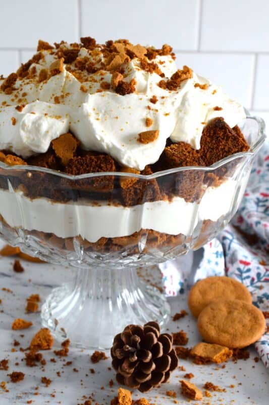 Homemade gingerbread cake makes up the bulk of this Gingerbread Trifle. Layered with fluffy whipped cream, crushed gingersnap cookies, and candied sugary ginger, this dessert is the perfect warm and cozy finish to a family holiday meal! #gingerbread #trifle #ginger #nobake