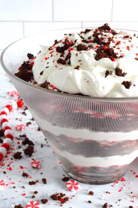 Prepared with two-bite brownies, decadent whipped cream, and crushed candy canes, this Brownie Candy Cane Trifle has all the flavours one craves at Christmastime! Take the easy route and purchase brownies at the grocer. Christmas no-bake desserts should be stress-free and relaxing after all! #peppermint #trifle #brownies #candycane