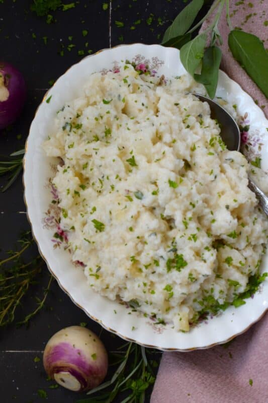 Swap out potatoes for turnips and lower both the calories and the carbs without compromising on taste! Herbed Mashed Turnip is rustic and simple, but the flavour suggests otherwise! Ground nutmeg and fresh herbs like rosemary, thyme, and sage will have you making this side over and over again! #turnip #side #mashed #veggies #thanksgiving