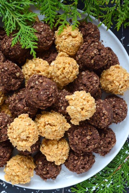 Fashioned much like a coconut macaroon, these No Bake Fiddle Diddles are all gussied up for the holidays! This recipe is quite easy; everything goes into one saucepan to combine, and then just drop spoonfuls of the mixture onto a lined baking sheet. Decorate with sprinkles, and candies, or leave them plain! Make both flavours because these are deliciously addictive! #nobake #fiddle #diddles #chocolate #peanutbutter #christmas