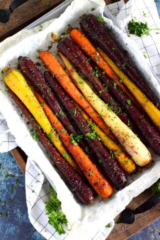 A wonderful, earthy side dish, Savoury Roasted Carrots combines dried pantry herbs with olive oil to make a home-style, rustic - and colourful! - side dish. Surprisingly simple, yet extremely delicious, this is one of my most popular holiday recipes! #carrots #roasted #heirloom