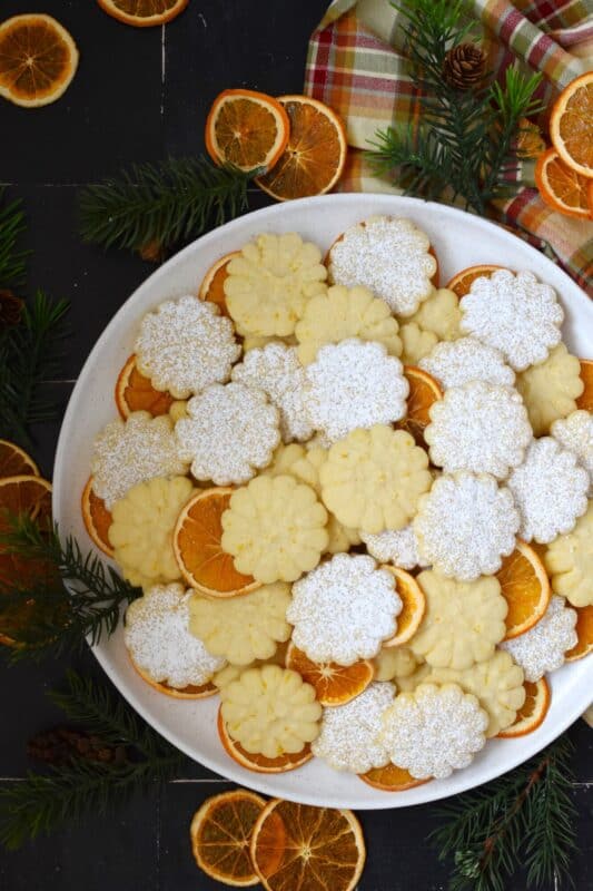 Slightly sweet and buttery with a burst of fresh citrus flavour, these Orange Spritz Cookies melt in your mouth! Every holiday cookie exchange or plate must have a spritz cookie, so I encourage you to try this classic recipe with an orange zest twist! #spritz #cookies #orange #zest