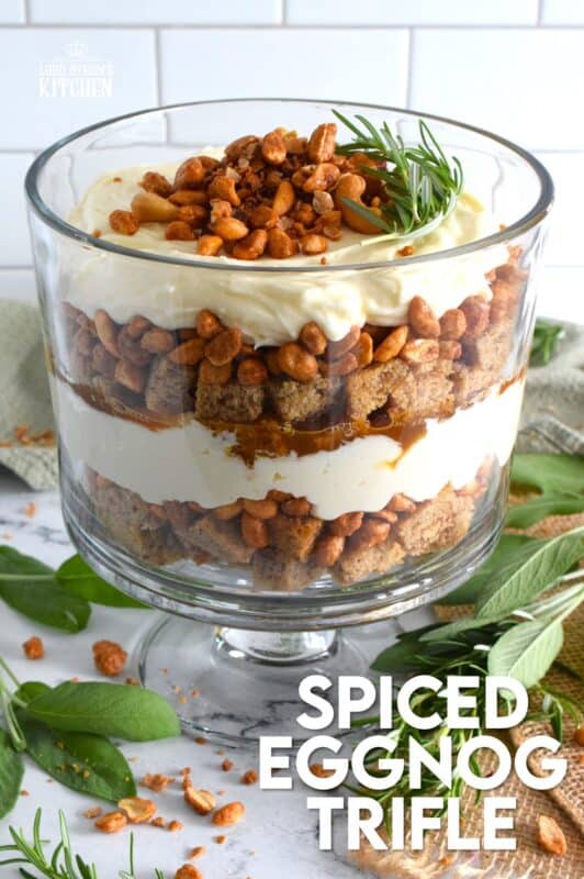 Starting with a homemade eggnog-infused, holiday rum cake, this Spiced Eggnog Trifle is layered with an eggnog cream cheese rum filling and candied mixed nuts.  Drizzled with a thick, sweet caramel sauce, this trifle is sure to be a hit!  Optionally, this recipe easily converts to a rum-free version too! #trifle #spiced #eggnog #cake #caramel #nuts