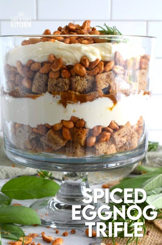 Starting with a homemade eggnog-infused, holiday rum cake, this Spiced Eggnog Trifle is layered with an eggnog cream cheese rum filling and candied mixed nuts.  Drizzled with a thick, sweet caramel sauce, this trifle is sure to be a hit!  Optionally, this recipe easily converts to a rum-free version too! #trifle #spiced #eggnog #cake #caramel #nuts