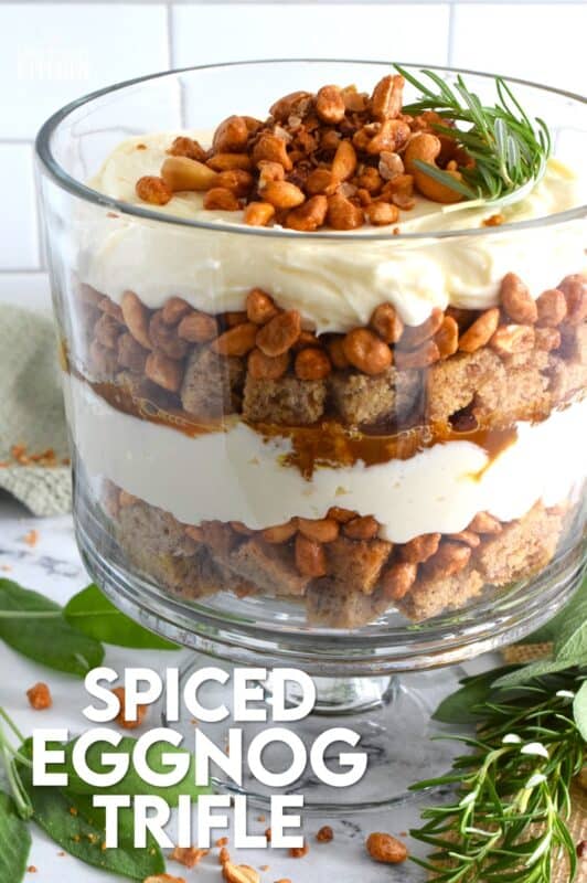Starting with a homemade eggnog-infused, holiday rum cake, this Spiced Eggnog Trifle is layered with an eggnog cream cheese rum filling and candied mixed nuts.  Drizzled with a thick, sweet caramel sauce, this trifle is sure to be a hit!  Optionally, this recipe easily converts to a rum-free version too! #trifle #spiced #eggnog #cake #caramel #nuts