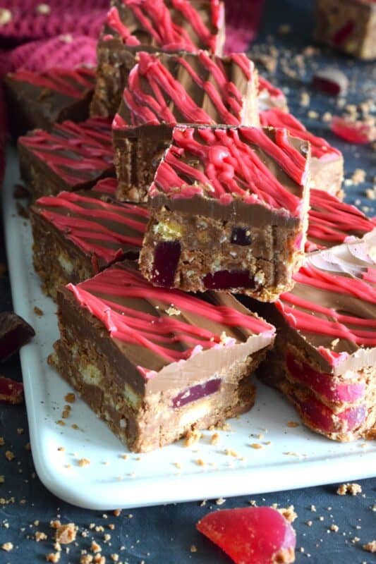 Prepared with Turkish Delight Chocolate Bars, these squares are flavoured with the familiar combination of rosewater, bergamot, and cinnamon. The chopped jellied candy is paired with condensed milk, coconut, crushed biscuits, and melted white chocolate. Turkish Delight Squares are extraordinarily delicious! #turkish #delight #rosewater #bergamot #nobake