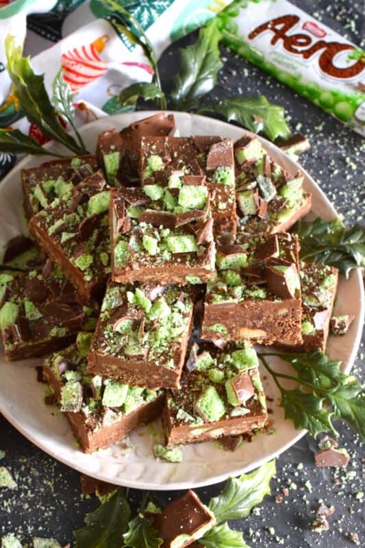 The airy, bubbly, chocolatey popular confection known as the Aero Bar, is paired with crushed cookies, cocoa powder, sweetened condensed milk, and melted milk chocolate in this No Bake Aero Mint Squares recipe. These are absolutely delicious, which makes sharing very difficult! #nestle #aero #mint #bars #nobake