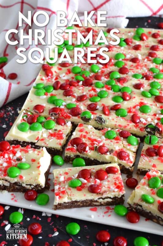 No Bake Christmas Squares have a rich, chocolatey base prepared with crushed cookies, cocoa, and brown sugar. They are topped with melted white chocolate, crushed candy canes, and holiday M&Ms. Only 25 minutes from start to finish! #mms #nobake #christmas #peppermint #cookies #bars #squares