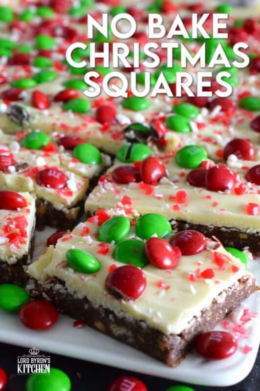 No Bake Christmas Squares have a rich, chocolatey base prepared with crushed cookies, cocoa, and brown sugar. They are topped with melted white chocolate, crushed candy canes, and holiday M&Ms. Only 25 minutes from start to finish! #mms #nobake #christmas #peppermint #cookies #bars #squares