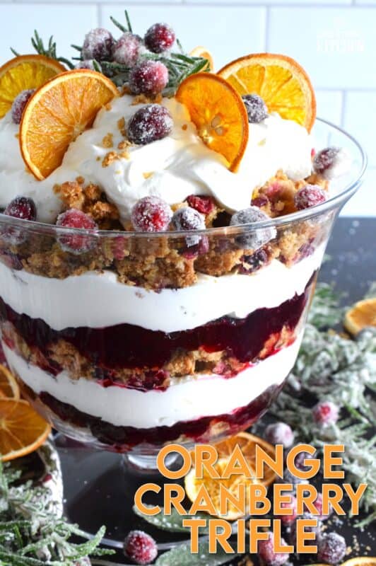 Freshly homemade cranberry squares are crumbled and layered with a delicious orange and rosemary-infused whipped cream. Topped with sugared cranberries and rosemary, this Orange Cranberry Trifle is a mouthwatering, showstopping holiday dessert! #trifle #cranberry #orange