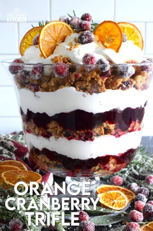Freshly homemade cranberry squares are crumbled and layered with a delicious orange and rosemary-infused whipped cream. Topped with sugared cranberries and rosemary, this Orange Cranberry Trifle is a mouthwatering, showstopping holiday dessert! #trifle #cranberry #orange