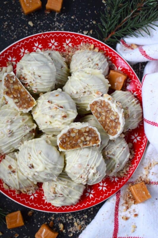 The combination of caramel candy, toasted pecans, and white chocolate make up these Pecan Caramel Clusters. They are a no-bake confection that requires just a few ingredients and hardly any skill at all! These clusters are rich and decadent - just as they should be at Christmastime! #caramel #pecan #kraft #chocolates #clusters #nobake