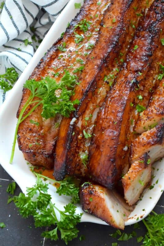 Roasted in a very hot oven, the thick skin on a slice of pork belly will develop a similar crispy and crunchy texture to that of chicharrones. Marinated and flavoured with simple seasonings and sauces found in most kitchens, this Roasted Pork Belly is baked until moist and tender, making this main easy to prepare and a delight to eat! #porkbelly #chicharrones #pork 