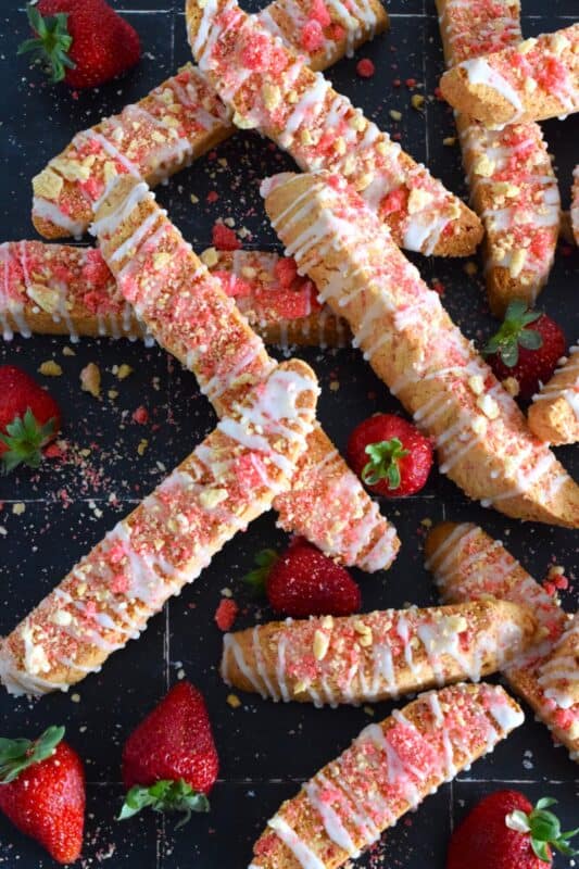 These biscotti are loaded with homemade strawberry shortcake crumbs and topped with a simple sugary glaze. Strawberry Shortcake Biscotti are light, airy, and delicious! Super easy to make, and with their cheerful inclination, no one could resist! Treat yourself to one of these with a hot tea on a lazy Sunday afternoon. #strawberry #shortcake #crumbs #cookies #biscotti #valentine