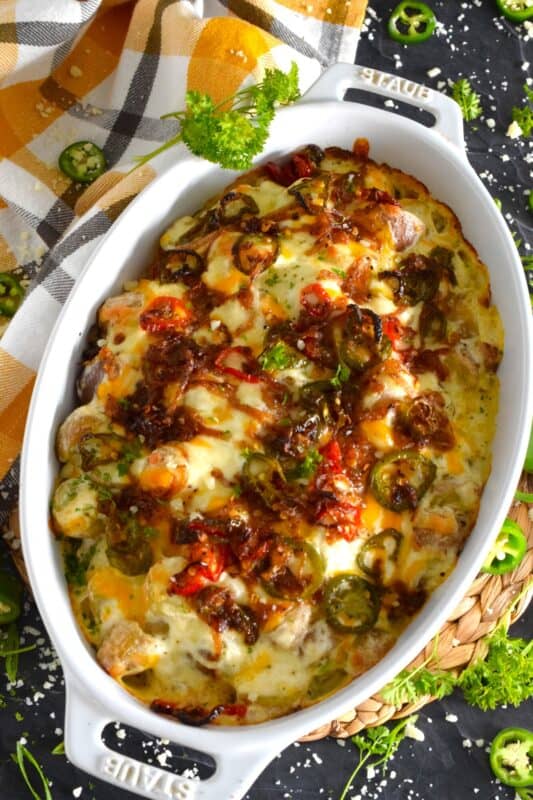 Cheesy Jalapeno Potatoes just might be my new obsession! Baby potatoes are tossed with seasonings, sour cream, and cheese and then transferred to a baking dish. Topped with caramelized onion and jalapenos, the potatoes are baked until browned and bubbly. These are simply amazing! #potatoes #cheesy #jalapenos #sourcream #bubbly #side
