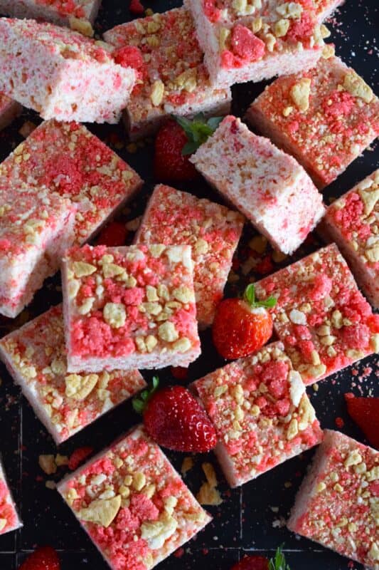 Strawberry Shortcake Rice Krispie Treats are loaded with those nostalgic pink and white cookie crumbs we all love! This no-bake confection is a favourite among kids both young and old, and they are easy to prepare and fun to eat too. These treats can also be prepared with vegan marshmallows if you have any dietary restrictions. #strawberry #shortcake #crumbs #ricekrispie #treats #squares #valentine #pink