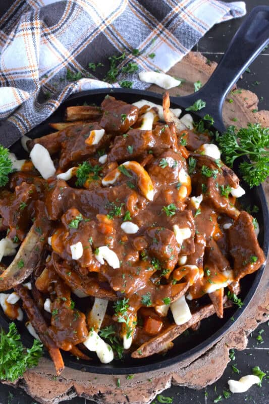Crispy, homemade fries, top with squeaky cheese curds, and smothered in a delicious beef gravy made with guinness beer, this Irish-inspired poutine adds a St. Patrick's Day twist to a popular Canadian dish that everyone loves to dig into! #stpatricksday #irish #poutine #beef #beer #guinness #stout #gravy
