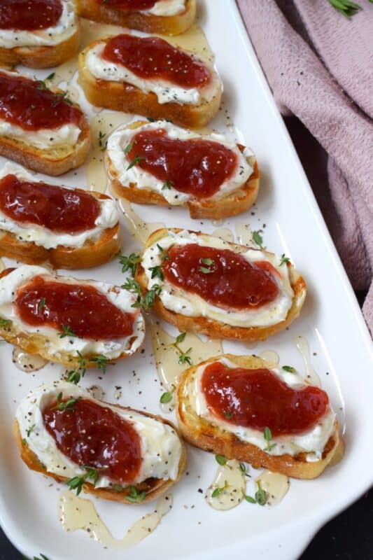 Spread with sweetened whipped cream cheese and topped with a homemade compote, this Savoury Rhubarb Crostini makes a lovely breakfast or brunch as well as a deliciously mouth-watering appetizer. Drizzle with honey and a sprinkling of fresh herbs for best results! #rhubarb #crostini #compote #appetizer
