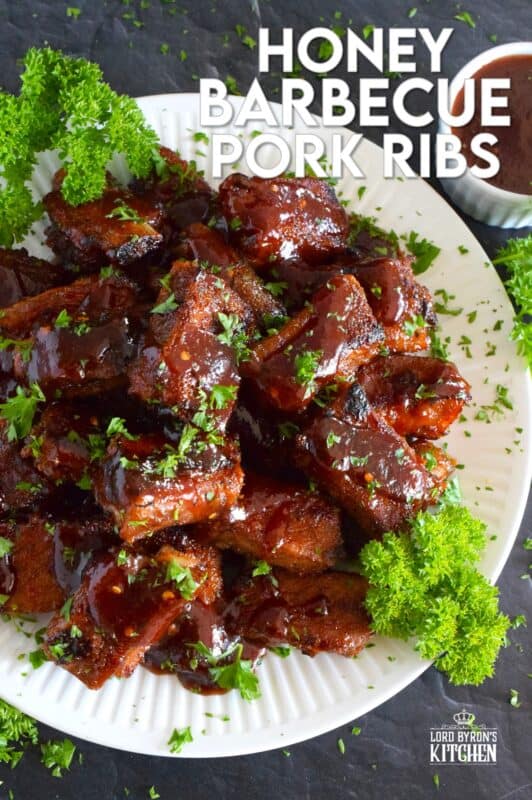 Moist and tender, these pork ribs are enclosed and baked to lock in flavour and texture before they are basted in a deliciously savoury and sweet honey barbecue sauce and broiled until slightly charred. Serve these ribs with lots of napkins, because the sauce is sticky and generous! #ribs #porkribs #honey #barbecue #bbq #baked