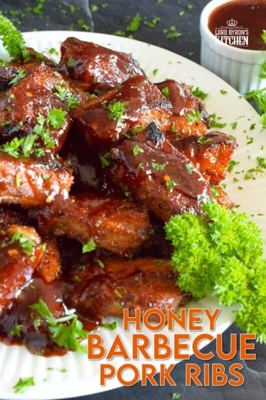 Moist and tender, these pork ribs are enclosed and baked to lock in flavour and texture before they are basted in a deliciously savoury and sweet honey barbecue sauce and broiled until slightly charred. Serve these ribs with lots of napkins, because the sauce is sticky and generous! #ribs #porkribs #honey #barbecue #bbq #baked