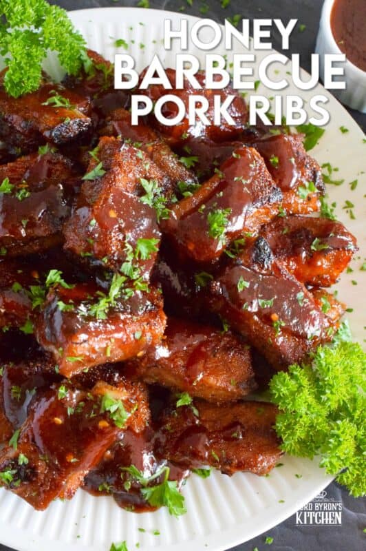 Moist and tender, these pork ribs are enclosed and baked to lock in flavour and texture before they are basted in a deliciously savoury and sweet honey barbecue sauce and broiled until slightly charred. Serve these ribs with lots of napkins, because the sauce is sticky and generous! #ribs #porkribs #honey #barbecue #bbq #baked