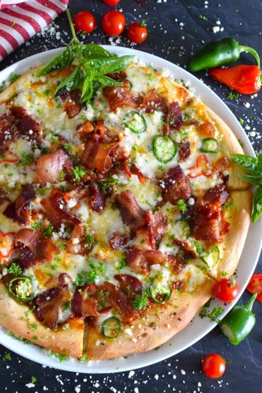 Shelf the tomato-based pizza sauce, because this Jalapeno Popper Pizza is not only prepared with an easy, homemade pizza dough, it's also made with a cream cheese spread. Loaded with lots of bacon, jalapenos, and mozzarella, this pizza is made to impress. Super flavourful with just the right amount of spice and heat, one slice is just a tease! #pizza #jalapeno #jalapenopopper #popper #homemade